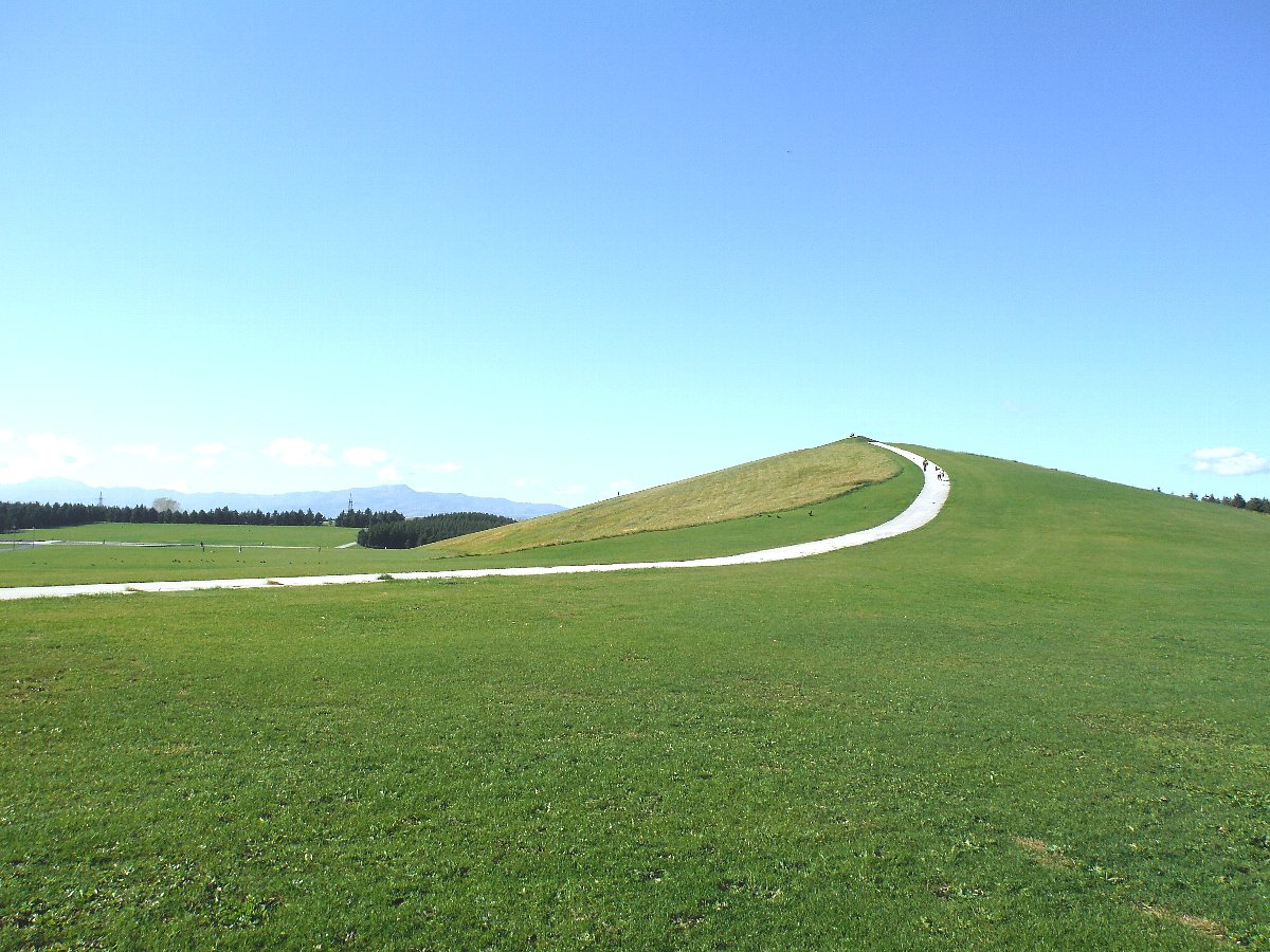 緑の芝生に覆われたプレイマウンテンの全景と山頂へ続く白い小道